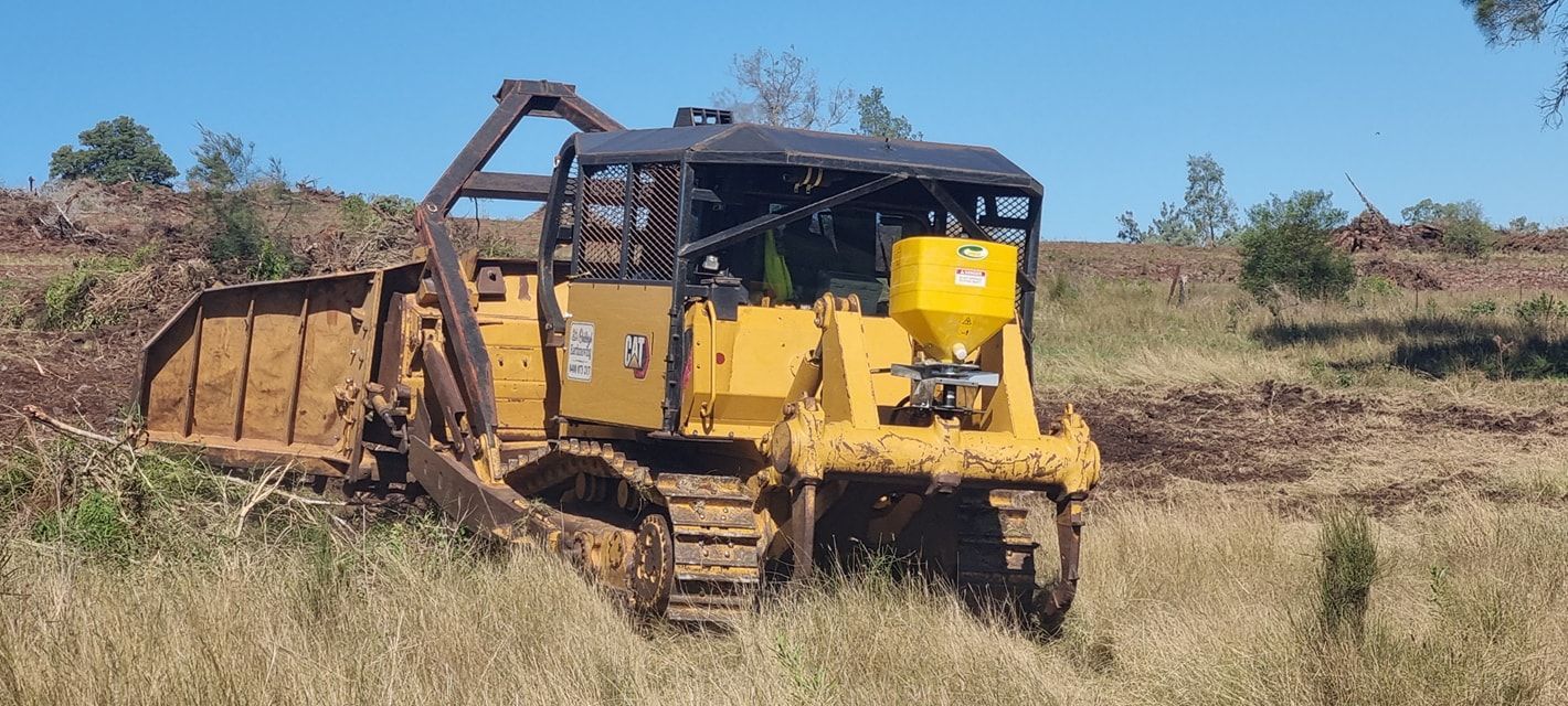 Yellow Tracked Bulldozer on a Dry Grassy Field, Clearing Brush in a Rural Area — Oakleigh Earthmoving in Warwick, QLD