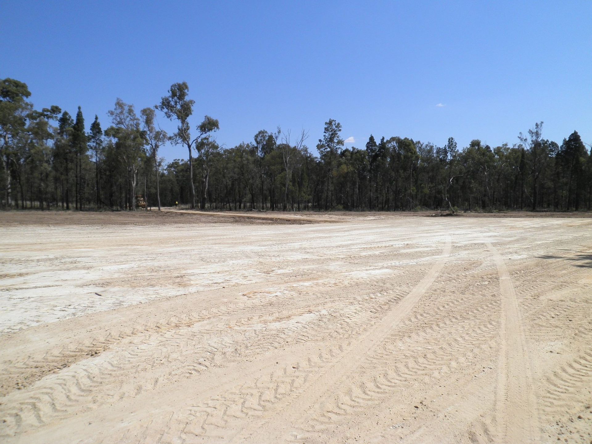 Sandy Clearing Under a Blue Sky With a Tree LINE in the Distance — Oakleigh Earthmoving in Chinchilla, QLD