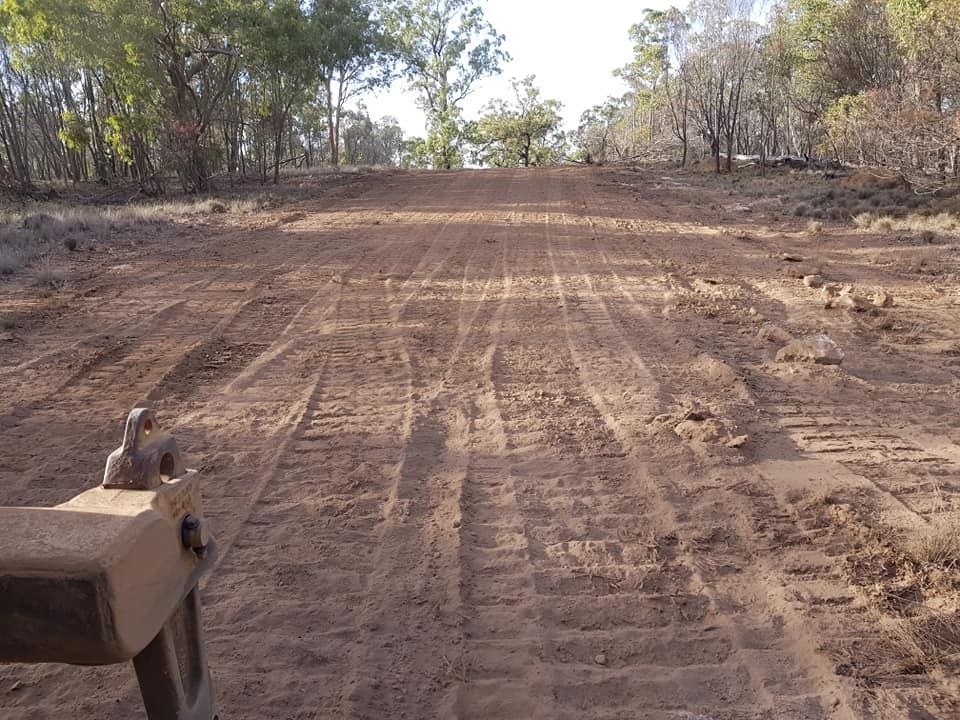 Rutted Dirt Road Through Dry Woodland, With Trees Lining Both Sides — Oakleigh Earthmoving in Kingaroy, QLD