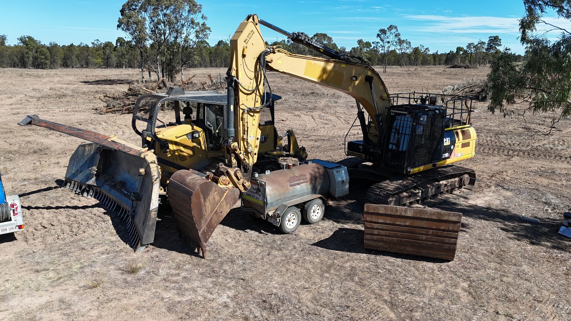 Excavator Loading a Dump Truck With Dirt in Dry Field, With Stacked Track Pads — Oakleigh Earthmoving in Cotswold Hills, QLD