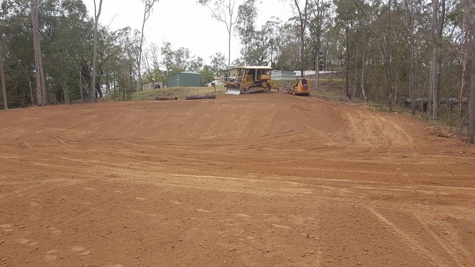 Cleared Dirt Lot With Heavy Machinery at the Top, Surrounded by Trees — Oakleigh Earthmoving in Toowoomba, QLD