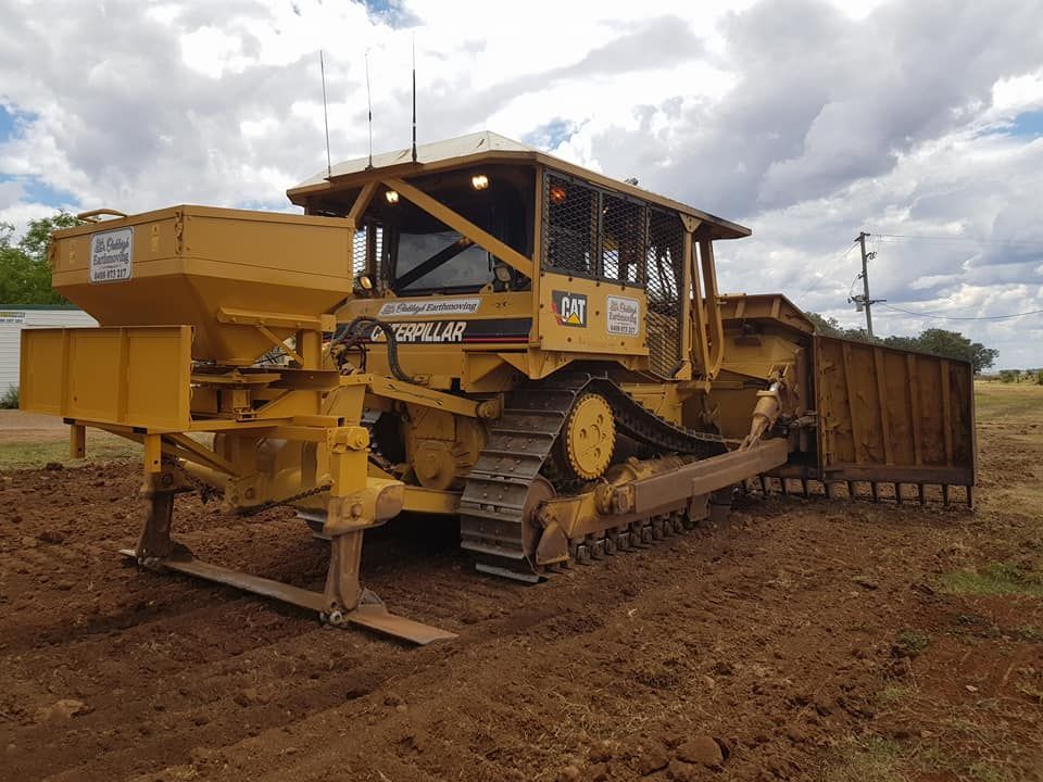 Yellow Caterpillar Bulldozer on Muddy Ground — Oakleigh Earthmoving in Toowoomba, QLD