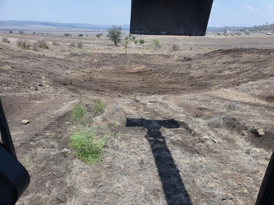 Dry Dirt Road Across a Barren Field Under a Clear Sky, Viewed From a Vehicle Window — Oakleigh Earthmoving in Warwick, QLD