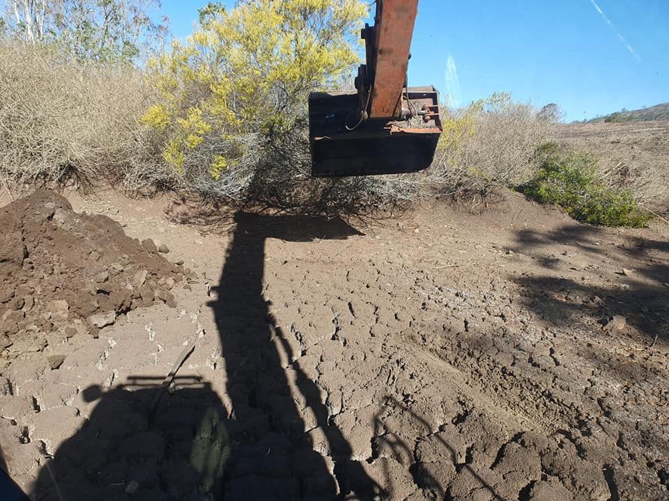 Excavator ARM Digging Dirt in a Dry, Open Construction Site Under a Clear Blue Sky — Oakleigh Earthmoving in Kingaroy, QLD