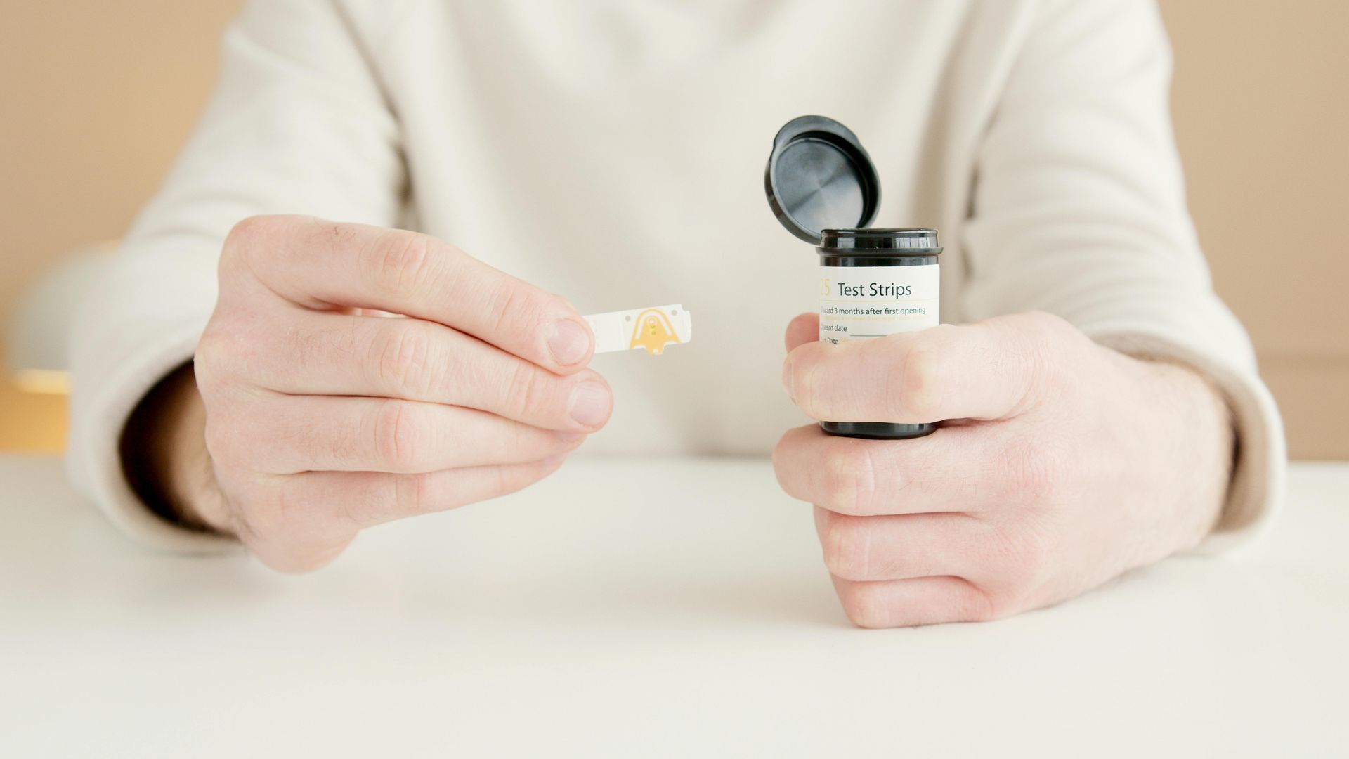 A person is holding a bottle of pills in their hands.