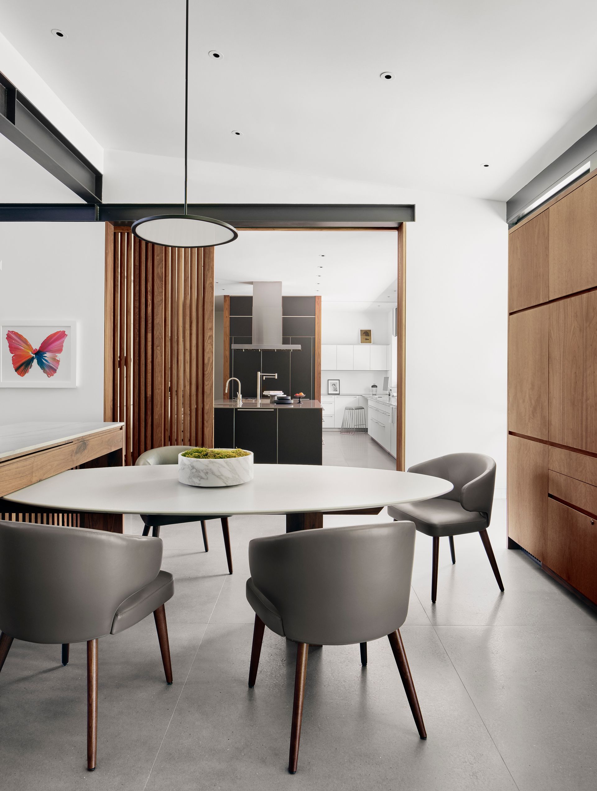 a dining room with a table and chairs and a picture of a butterfly on the wall