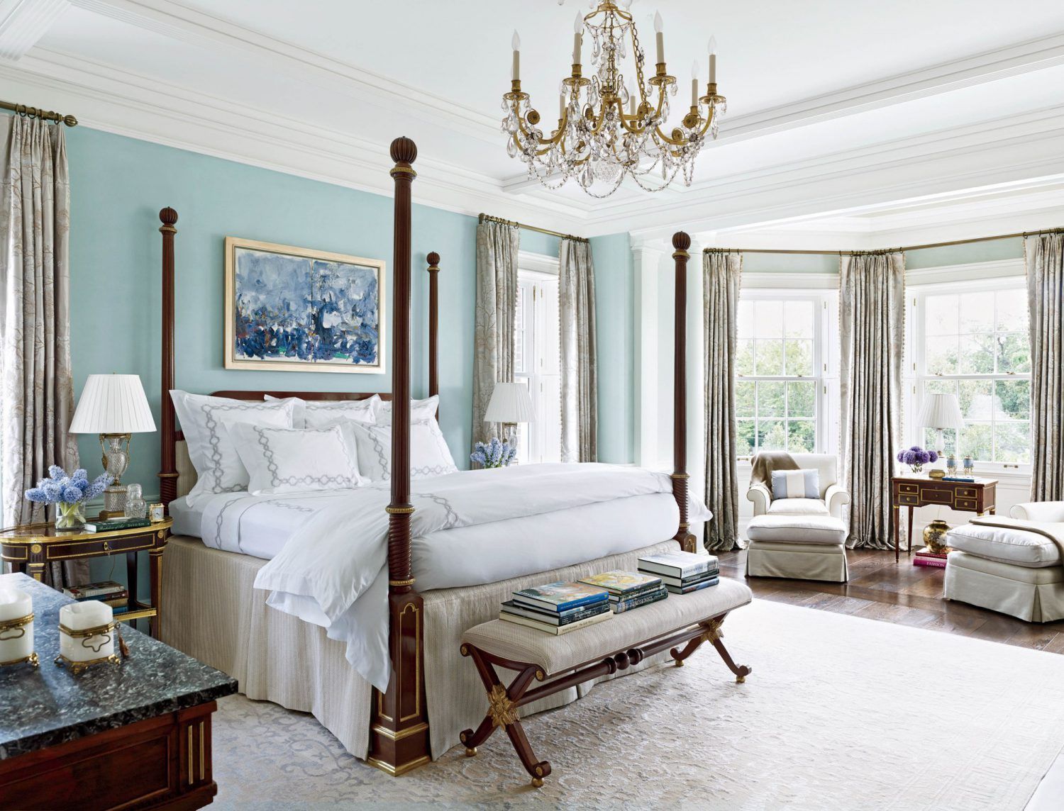 a bedroom with a four poster bed and a chandelier .