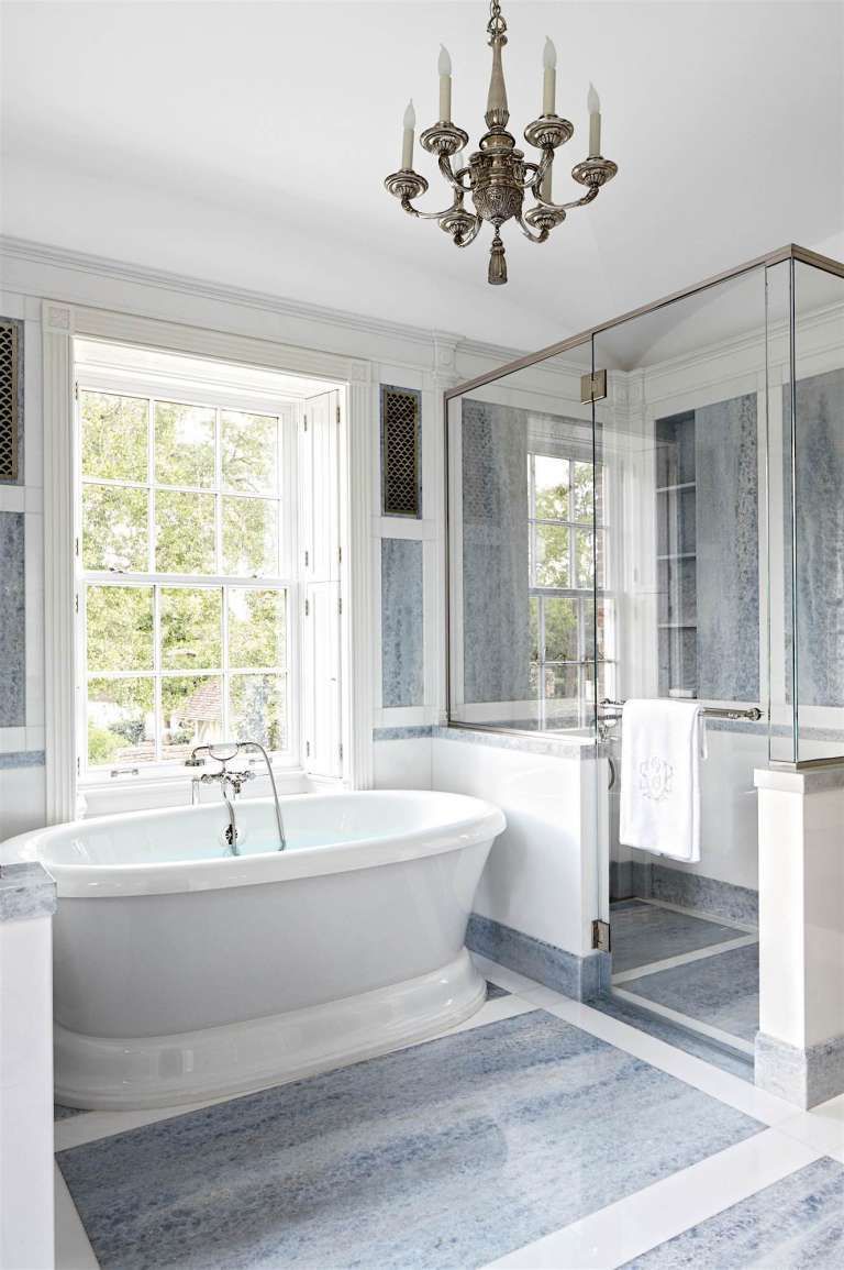 a bathroom with a tub and a chandelier hanging from the ceiling .
