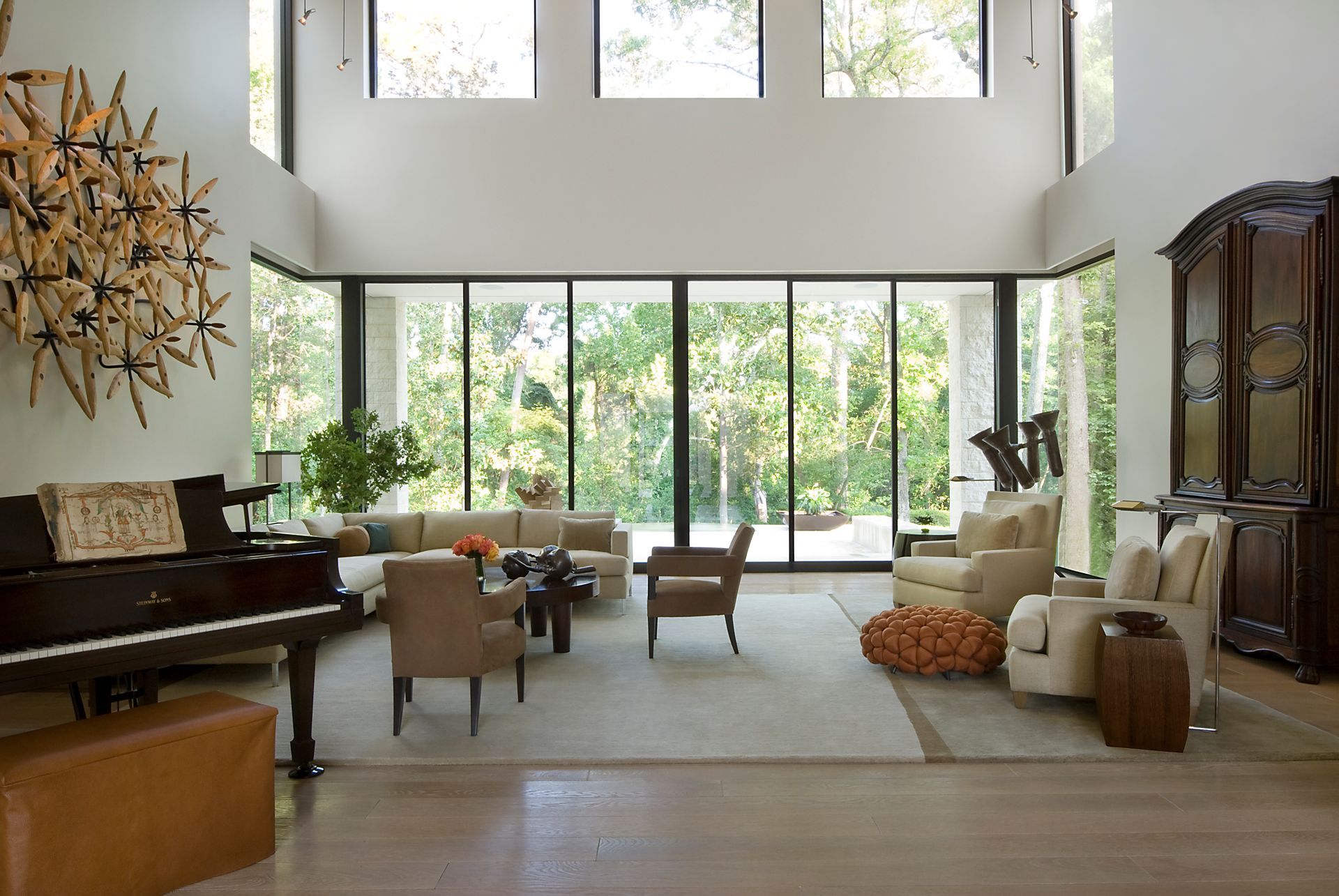 a living room with a piano and lots of windows