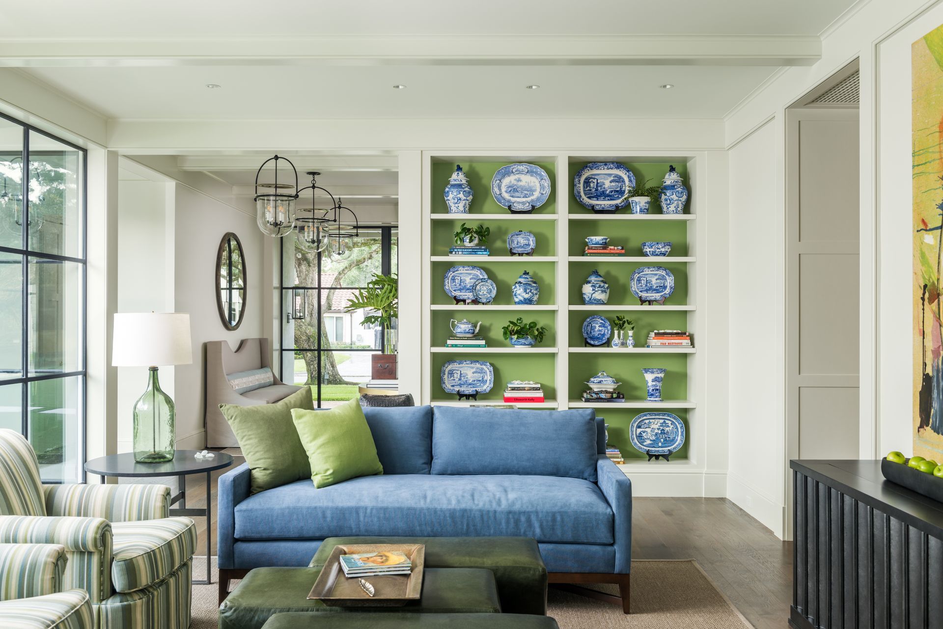 a living room with a blue couch and green ottomans