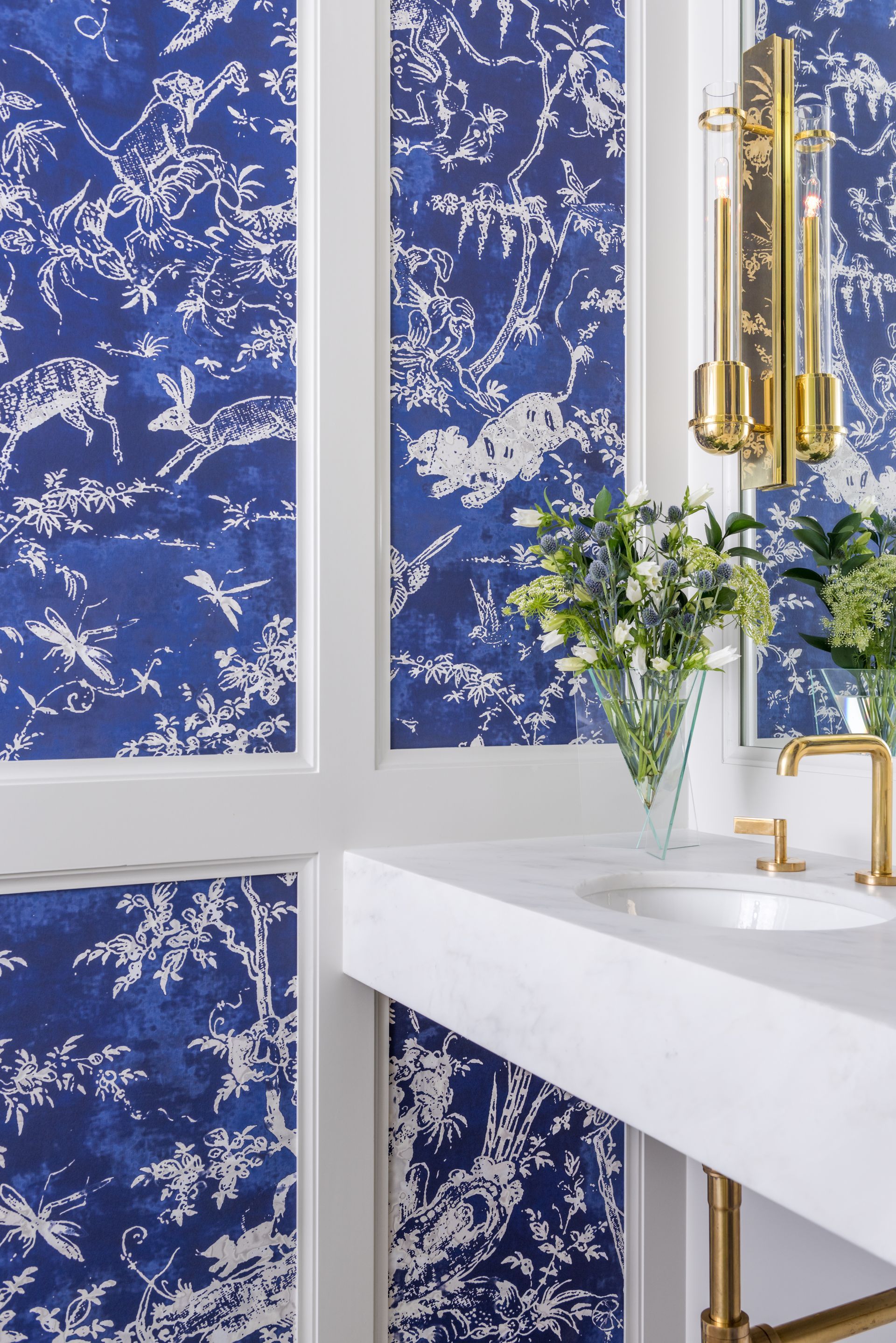 a bathroom with blue and white wallpaper and a sink