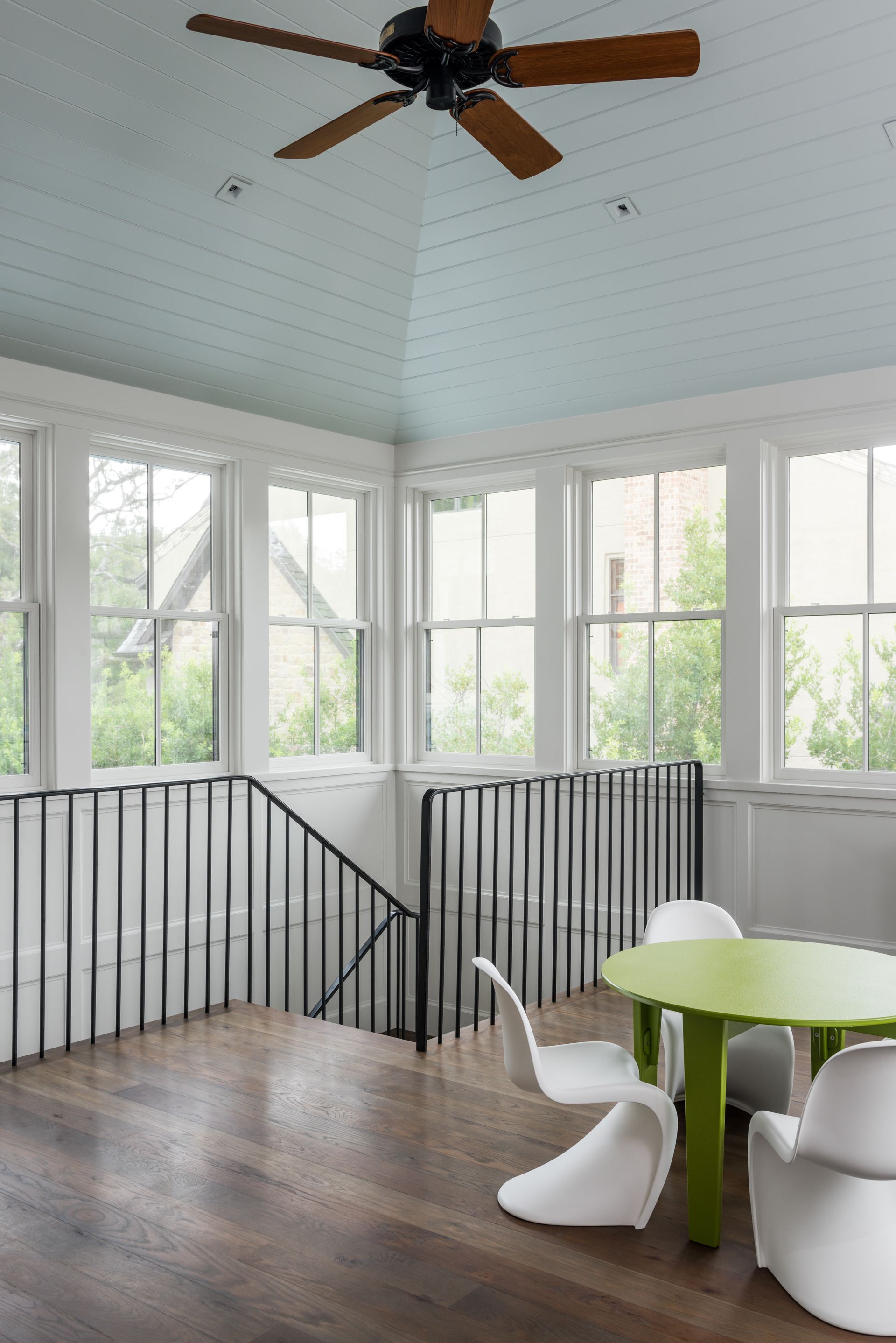 a room with a table and chairs and a ceiling fan