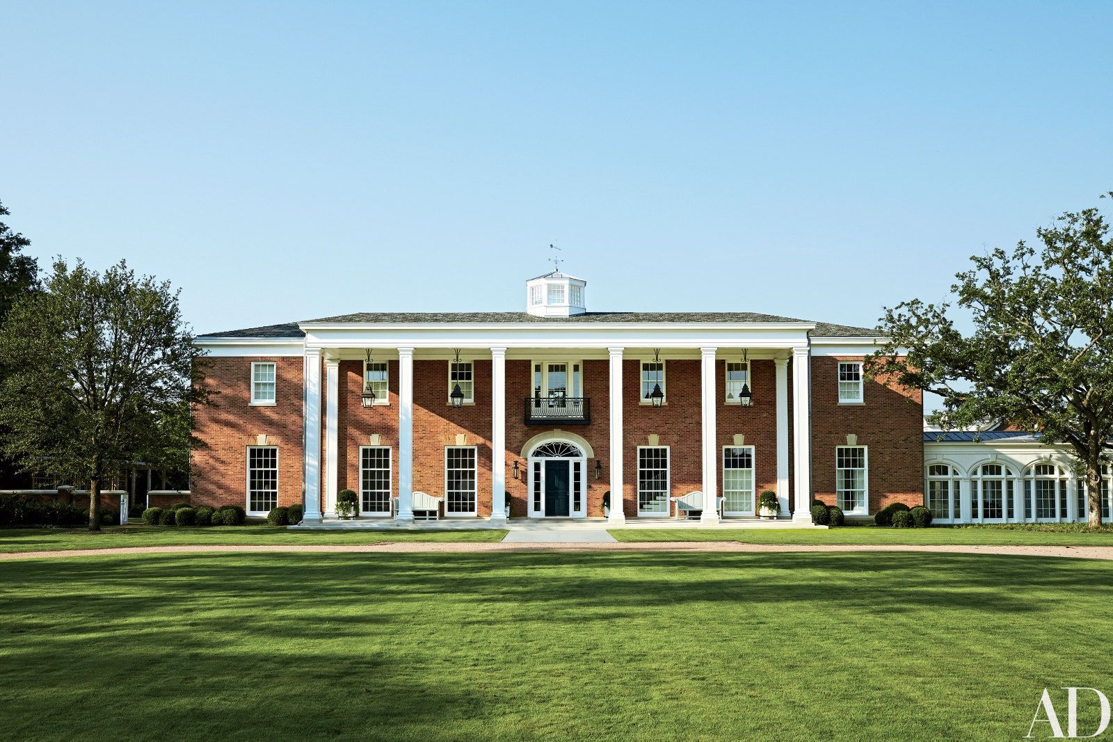 a large brick building with white columns and a blue door