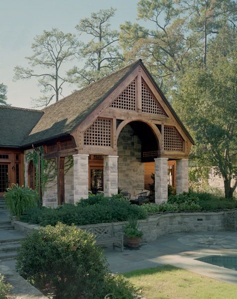 a large house with a wooden roof is surrounded by trees and bushes