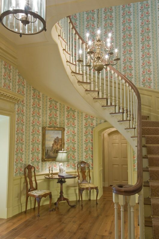 a curved staircase with a chandelier hanging from the ceiling