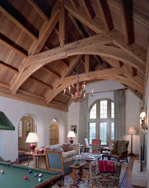 a living room with a pool table and a chandelier
