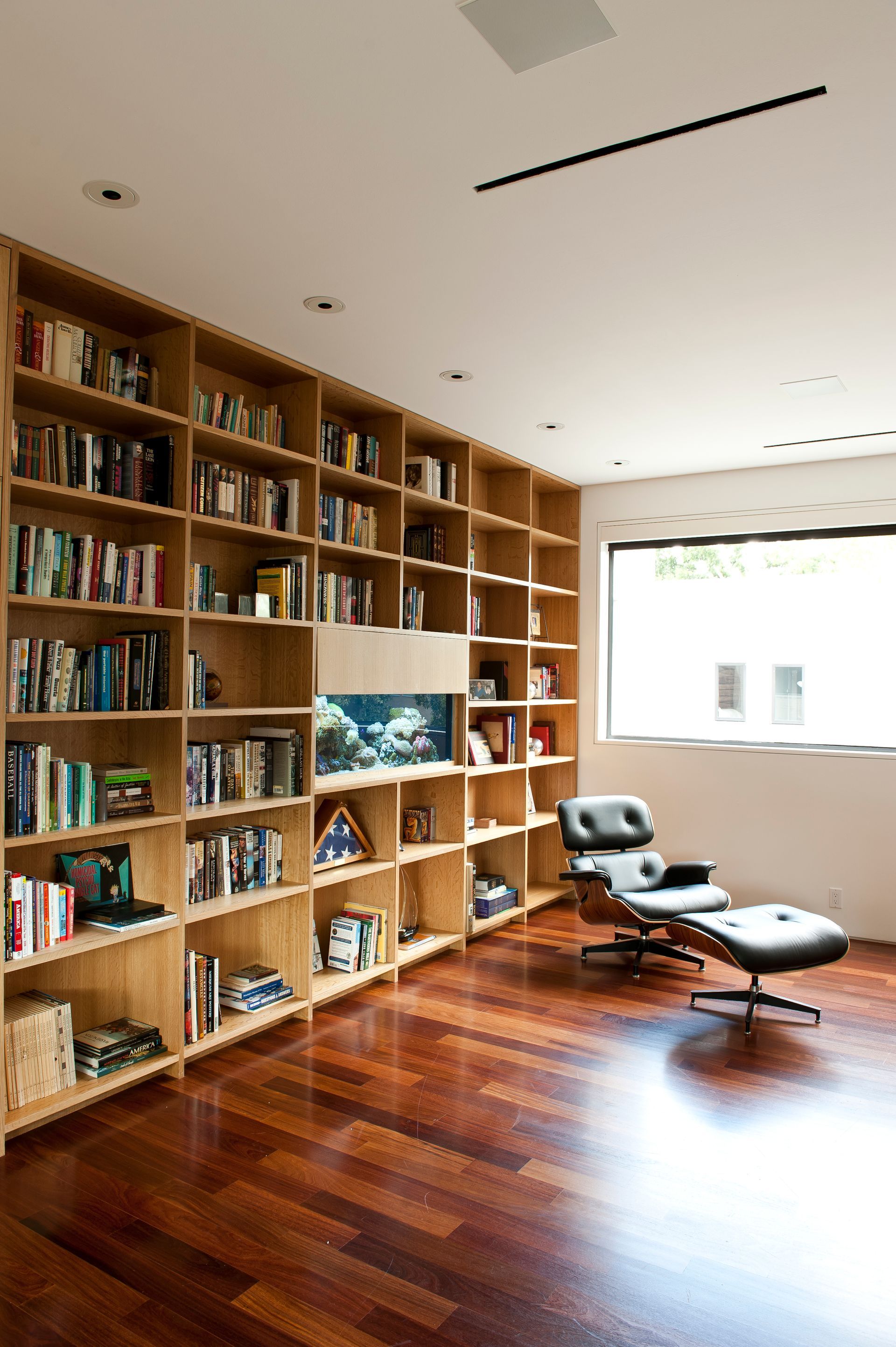 a living room with lots of bookshelves and a chair