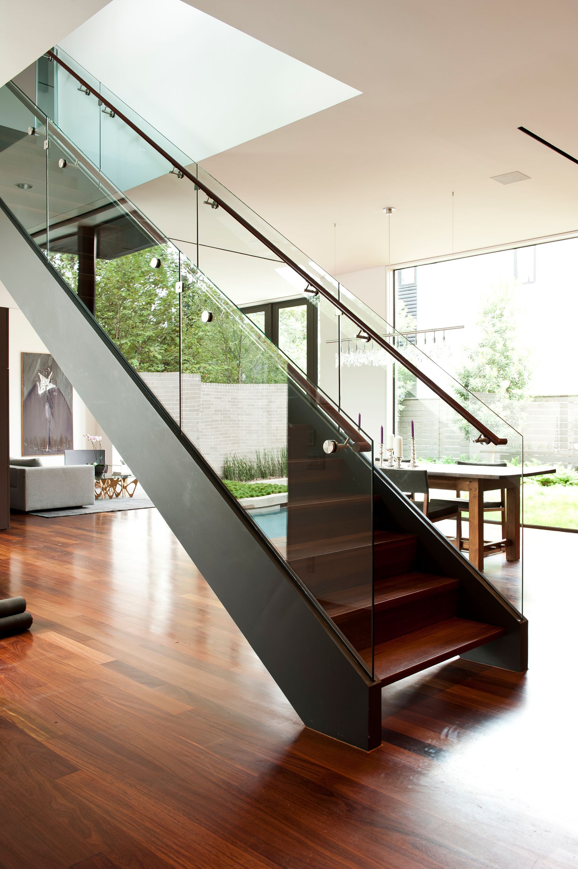a modern staircase with a glass railing in a living room