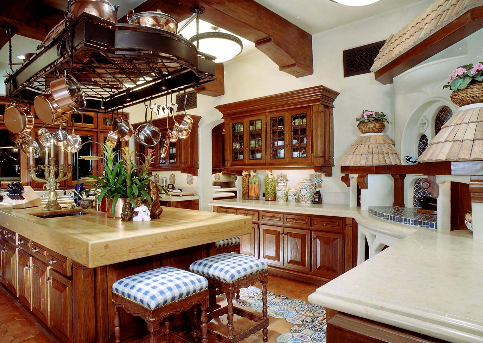 a kitchen with copper pots and pans hanging from the ceiling