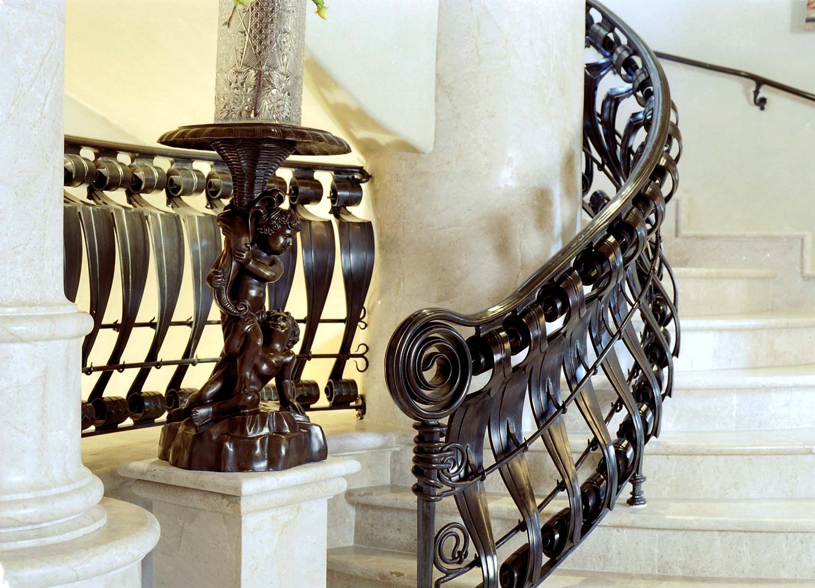 a staircase with a wrought iron railing and a candle holder