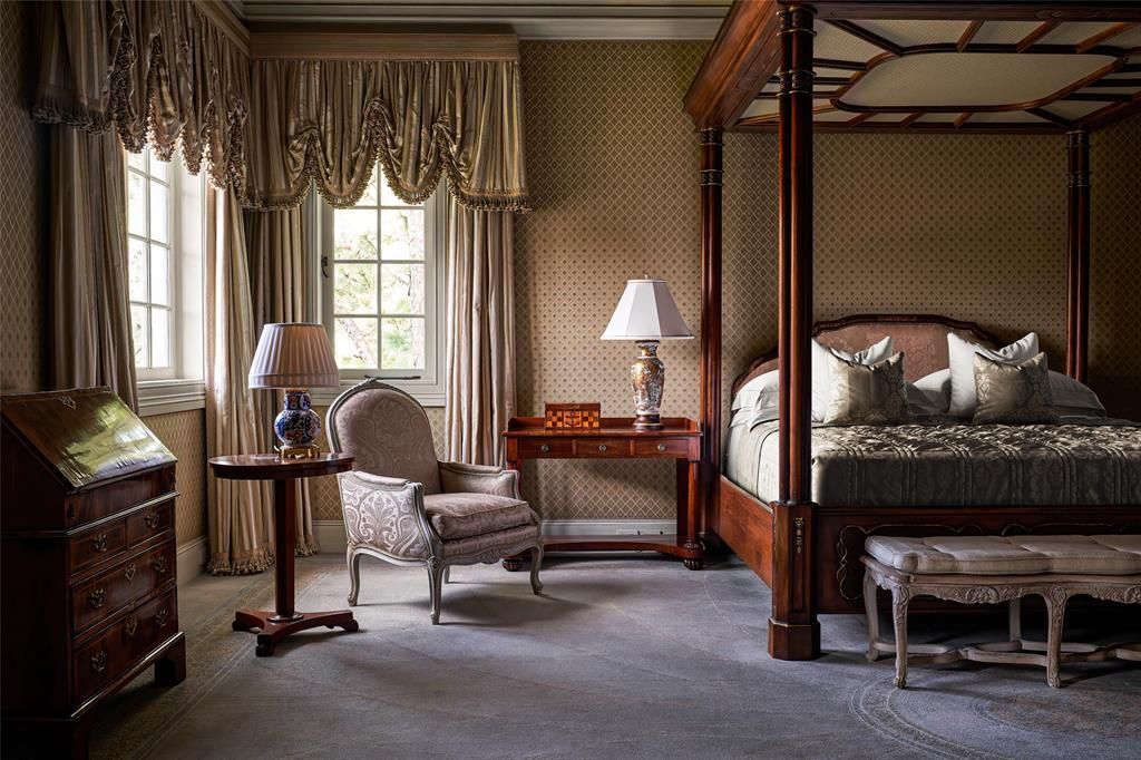 there is a four poster bed in the middle of the room .