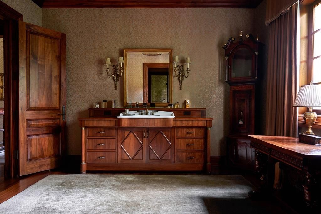a bathroom with a sink , mirror and clock .
