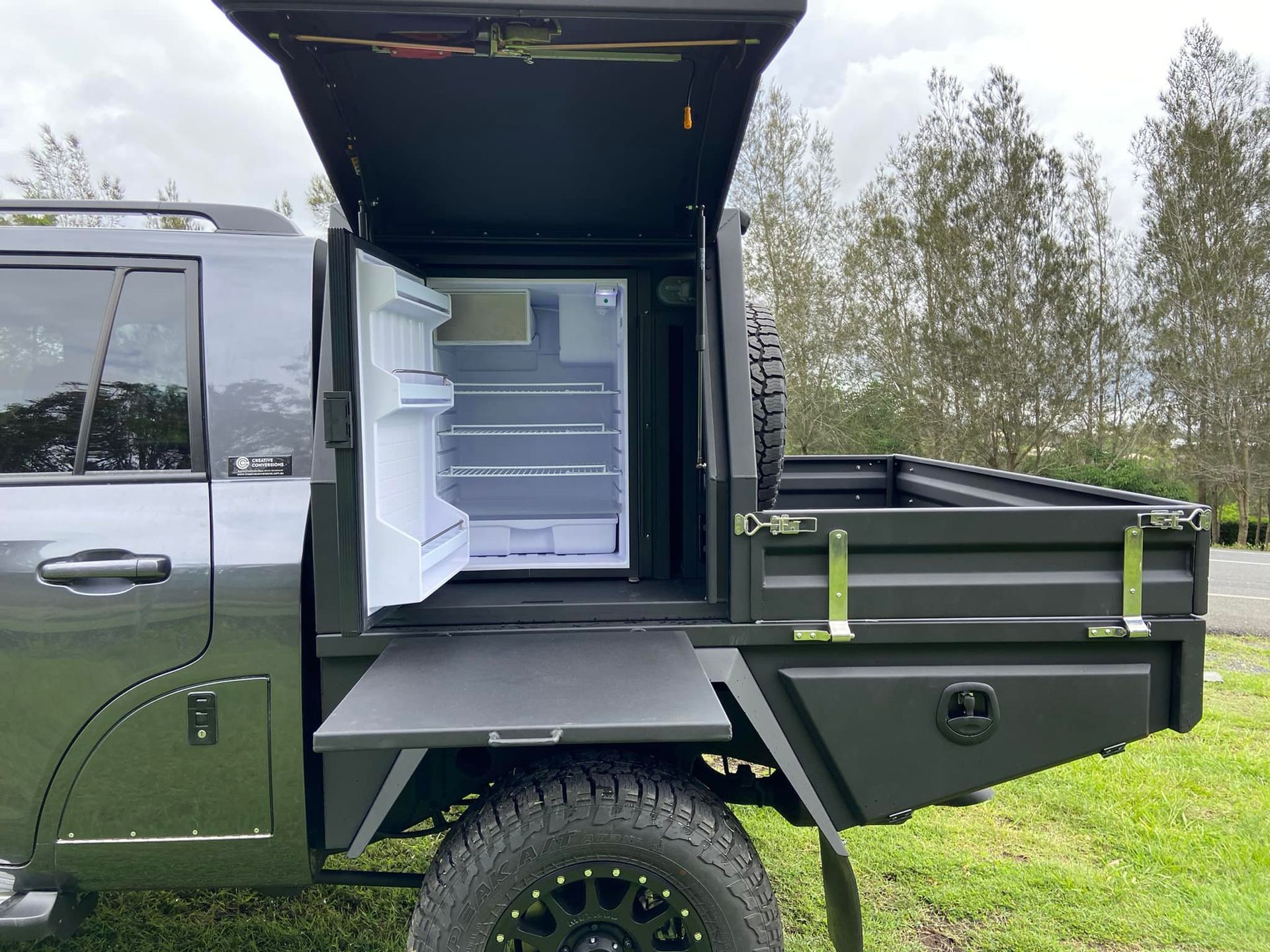 Dark gray pickup truck with open side compartment, refrigerator inside, open on the side. — Custom RV Creations & Repairs in Sumner, QLD
