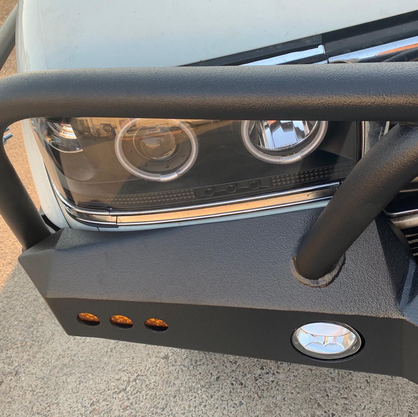 Black aftermarket bumper on a white truck, with headlights and amber lights. — Custom RV Creations & Repairs in Sumner, QLD