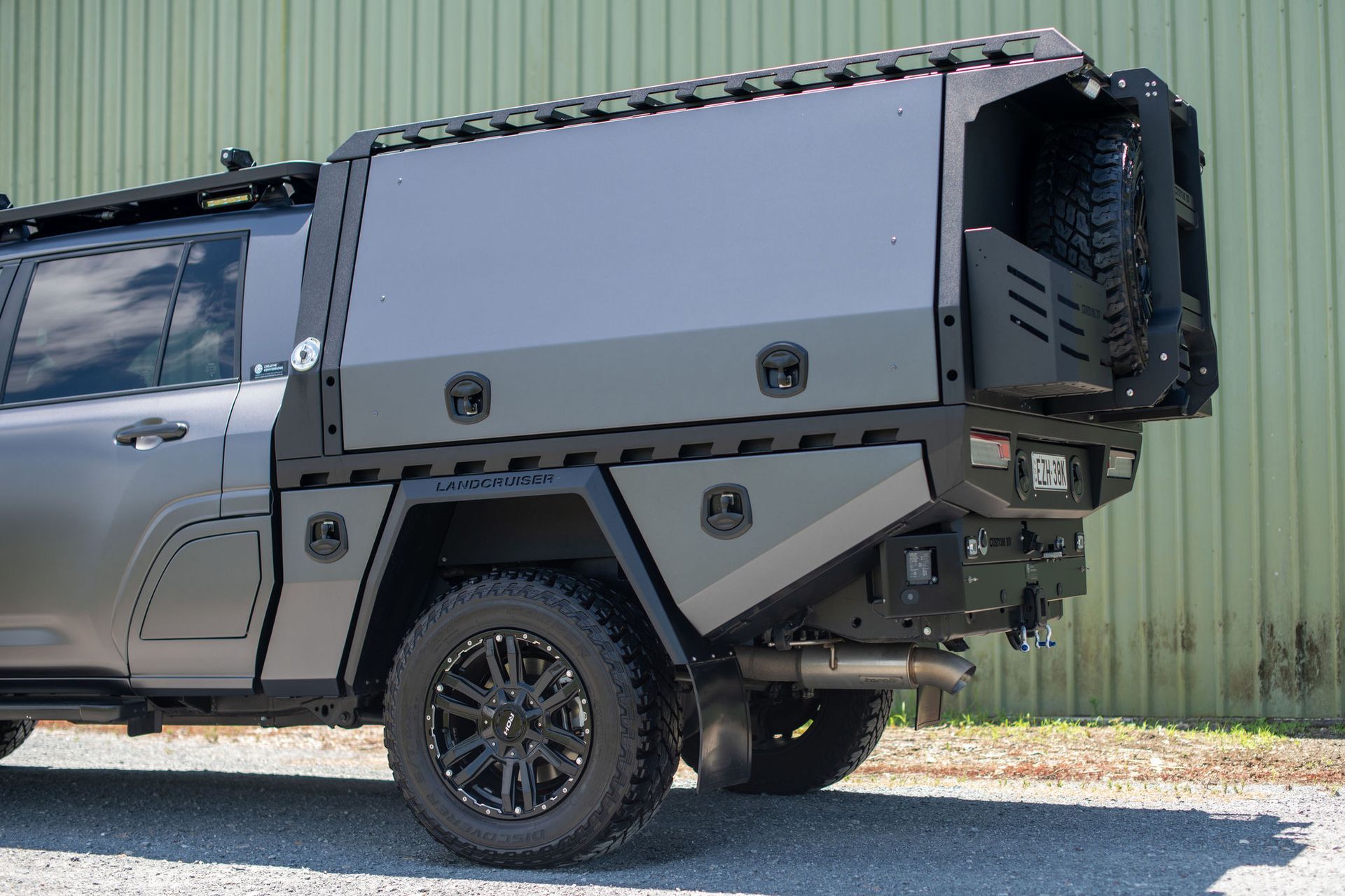 Grey Off-road Truck With a Custom Canopy, Spare Tire Carrier, and Black Wheels — Custom RV Creations in Sumner, QLD