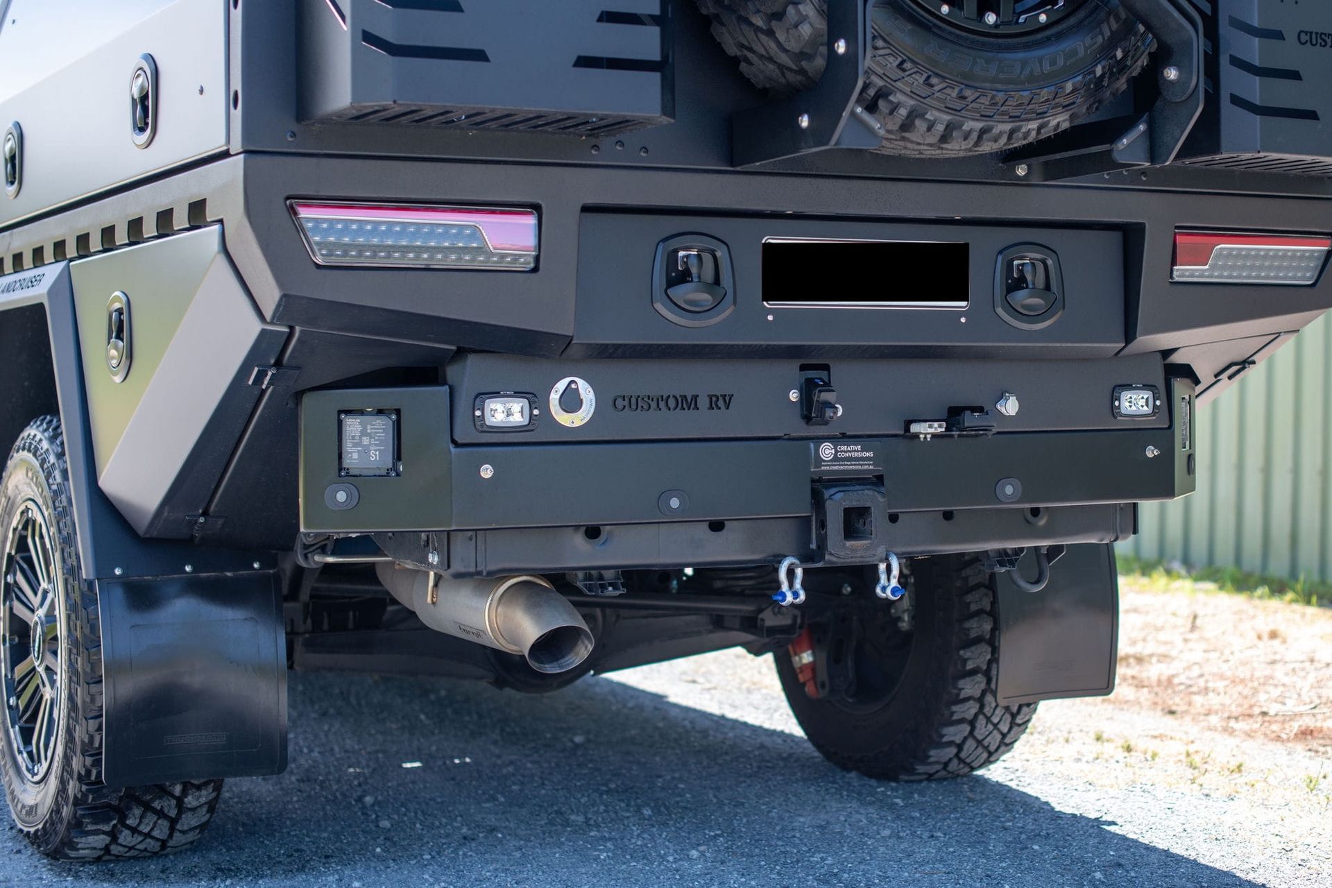 Rear of a black truck with a custom bumper, spare tire, and towing accessories. — Custom RV Creations & Repairs in Sumner, QLD