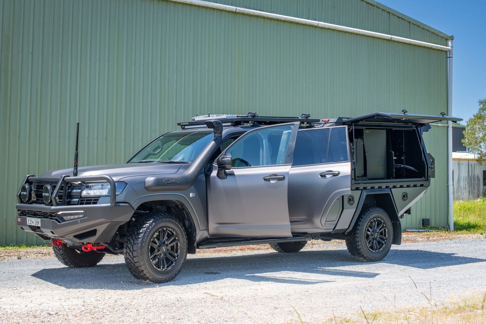 Grey Off-road SUV With Black Accessories Parked in Front of a Green Building — Custom RV Creations in Sumner, QLD