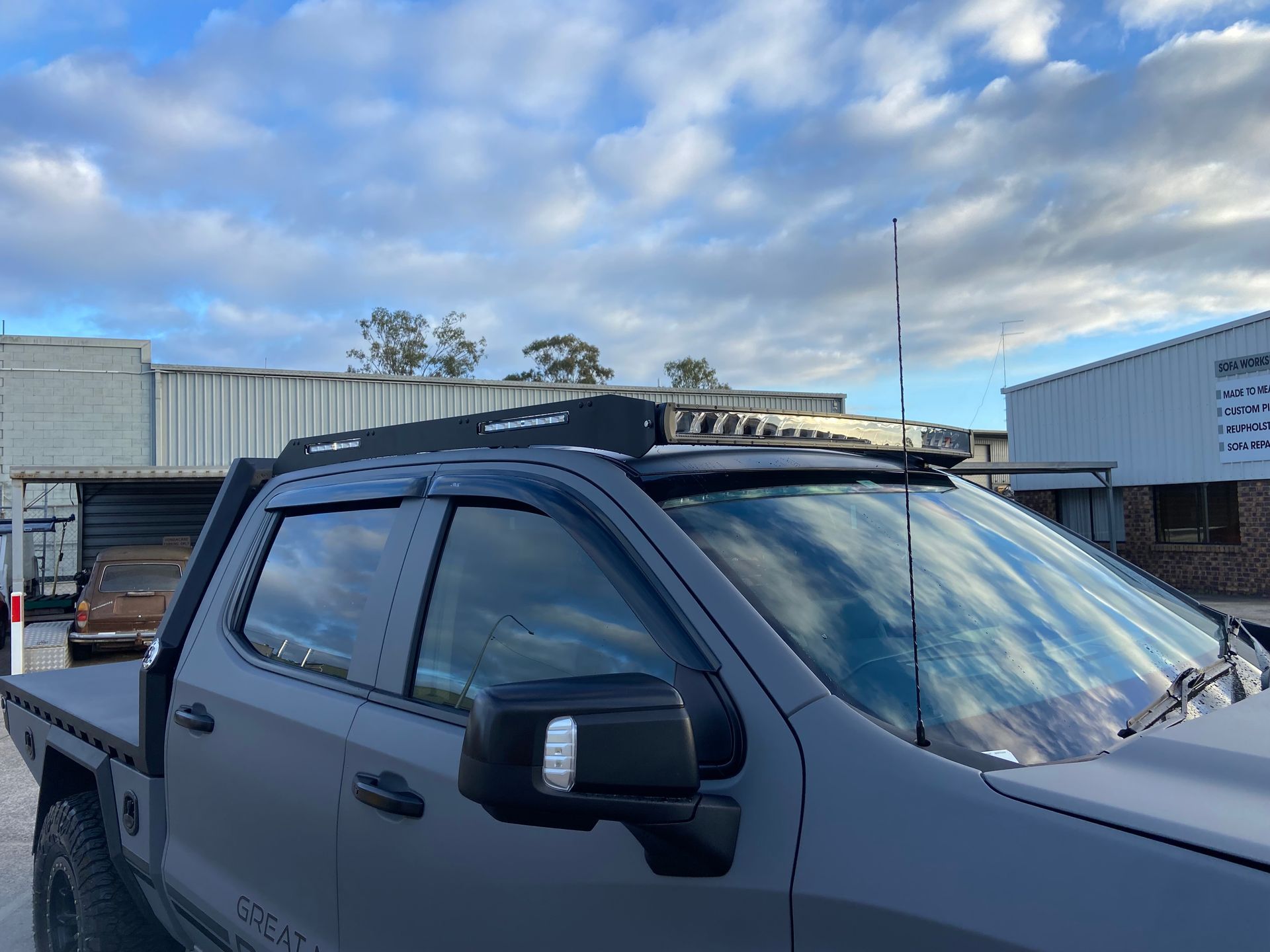 Grey Pickup Truck With a Black Roof Rack and Antenna Against a Cloudy Sky — Custom RV Creations in Sumner, QLD