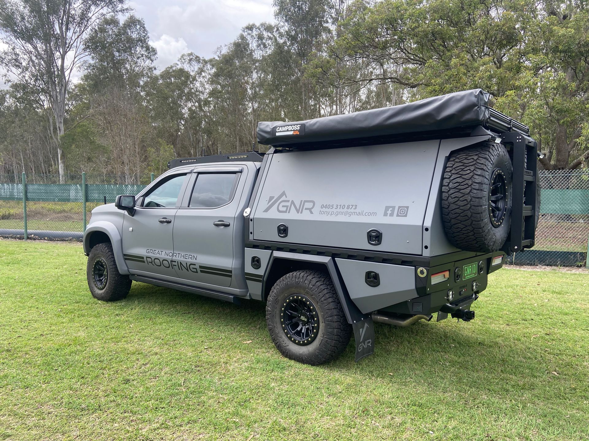 Off-road Pickup Truck With Camper Shell Parked on Grass — Custom RV Creations in Sumner, QLD