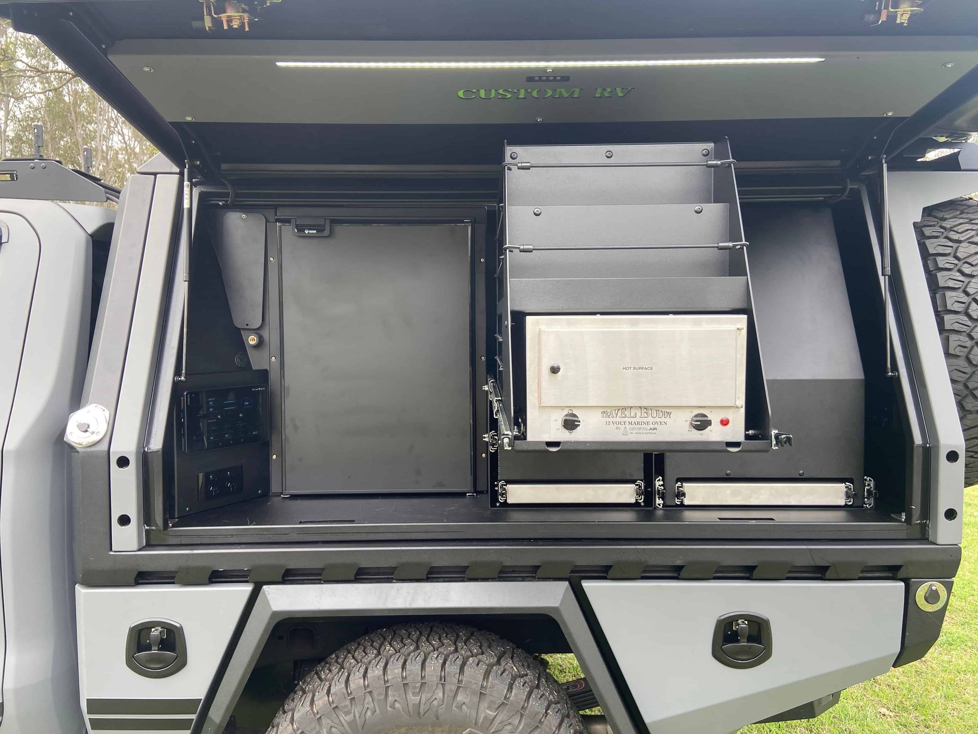 Gray truck bed with built-in storage compartments, shelves, and equipment, with an open top. — Custom RV Creations & Repairs in Sumner, QLD