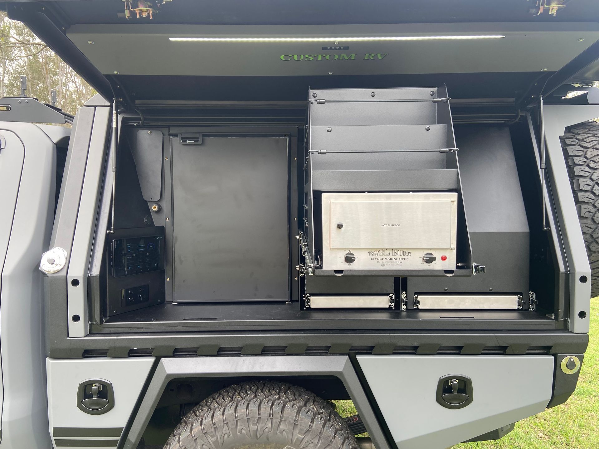 Grey Truck Bed With a Compartment Housing Shelves, a Refrigerator, and Electronic Equipment — Custom RV Creations in Sumner, QLD