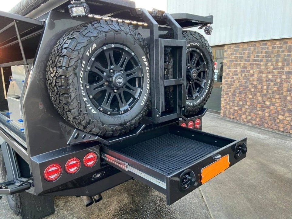 A Vehicle With a Tire Rack Attached to the Back of It — Custom RV Creations & Repairs in Sumner, QLD