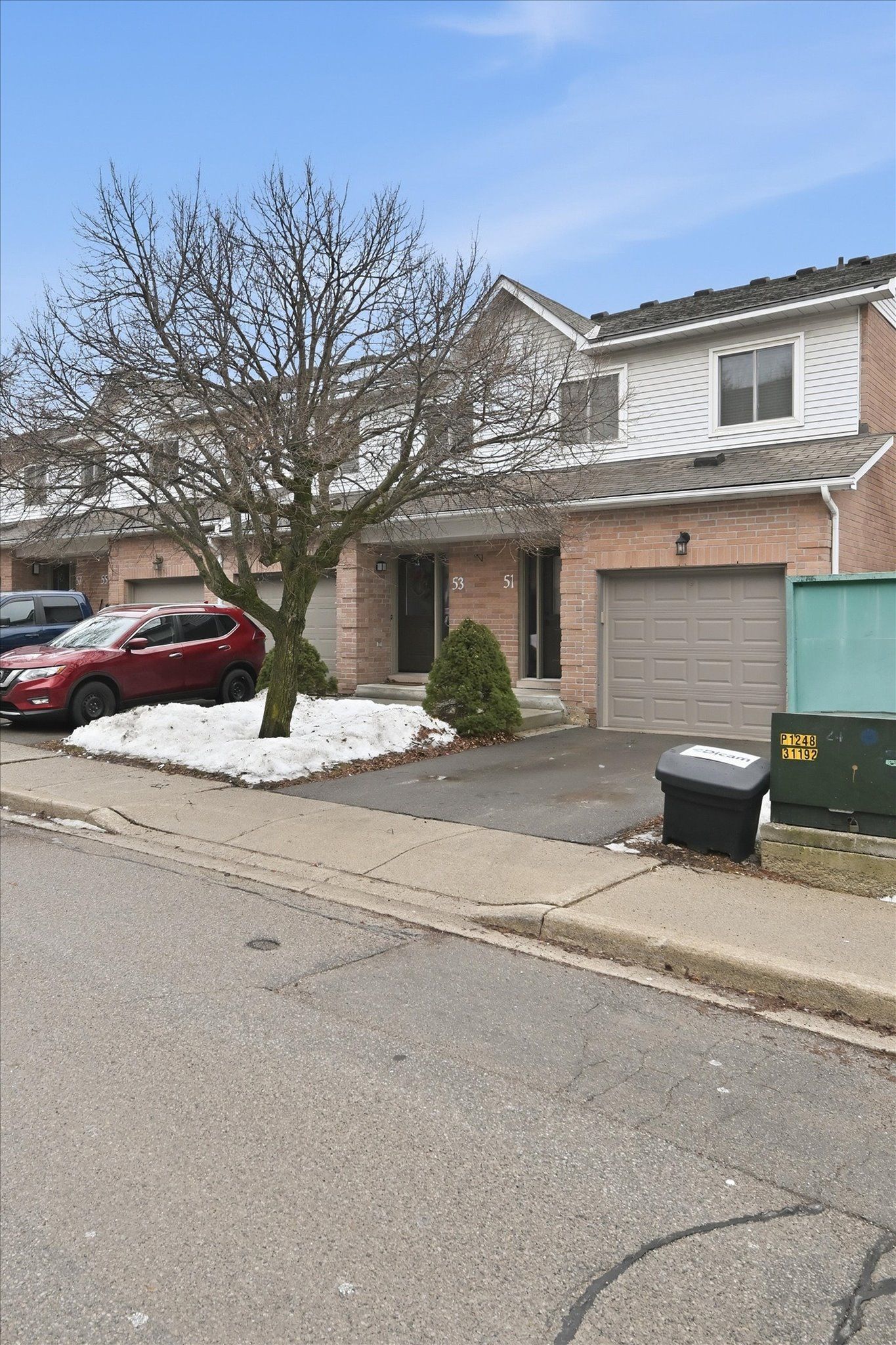 End unit townhome in Livingstone Lane Condominiums Dundas Hamilton with attached garage and brick exterior