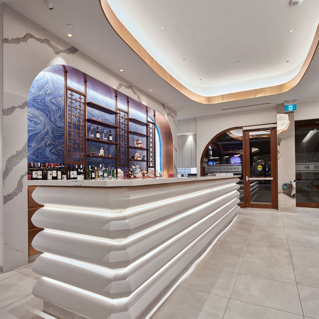 A large white bar in a restaurant with bottles on it