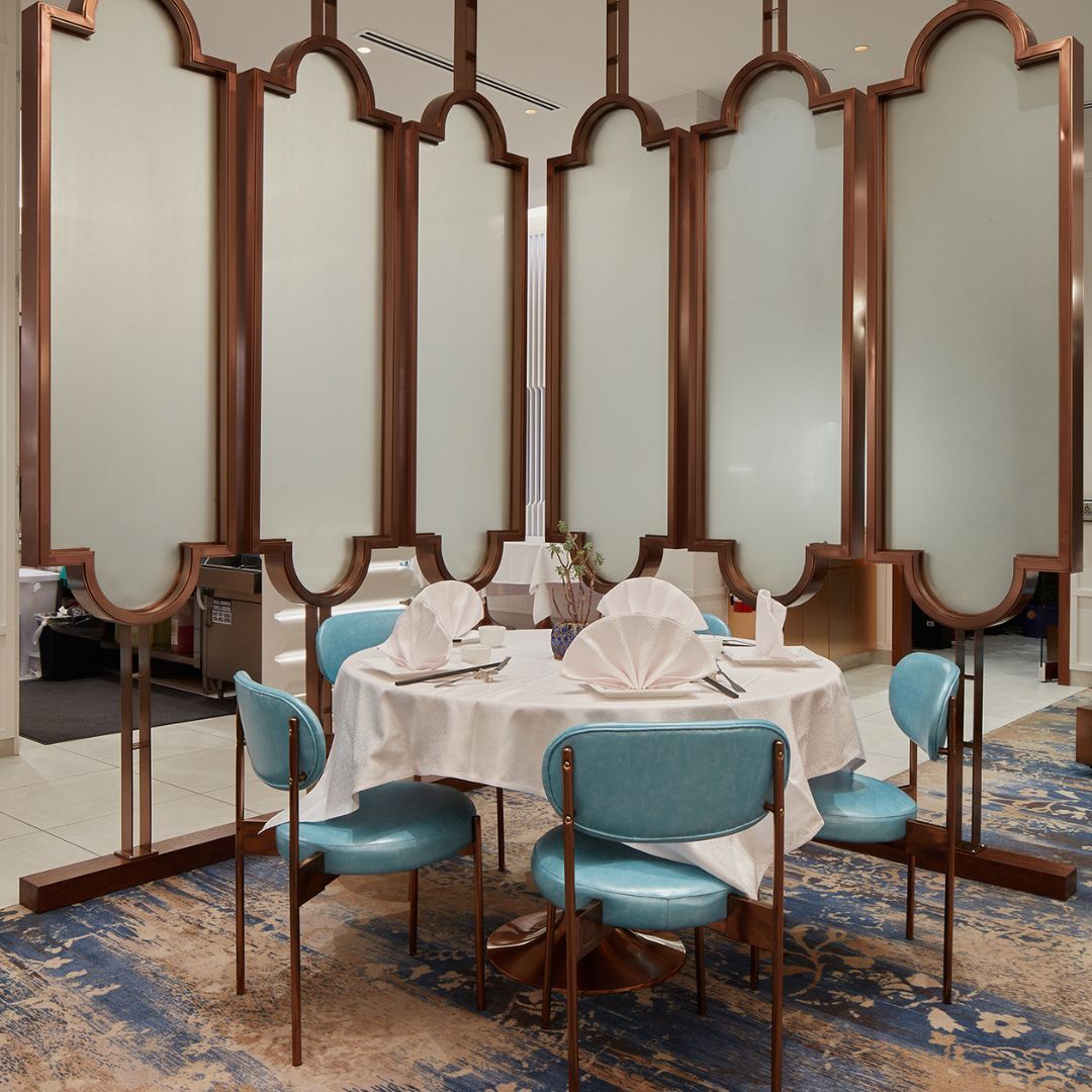 A dining room with a round table and blue chairs