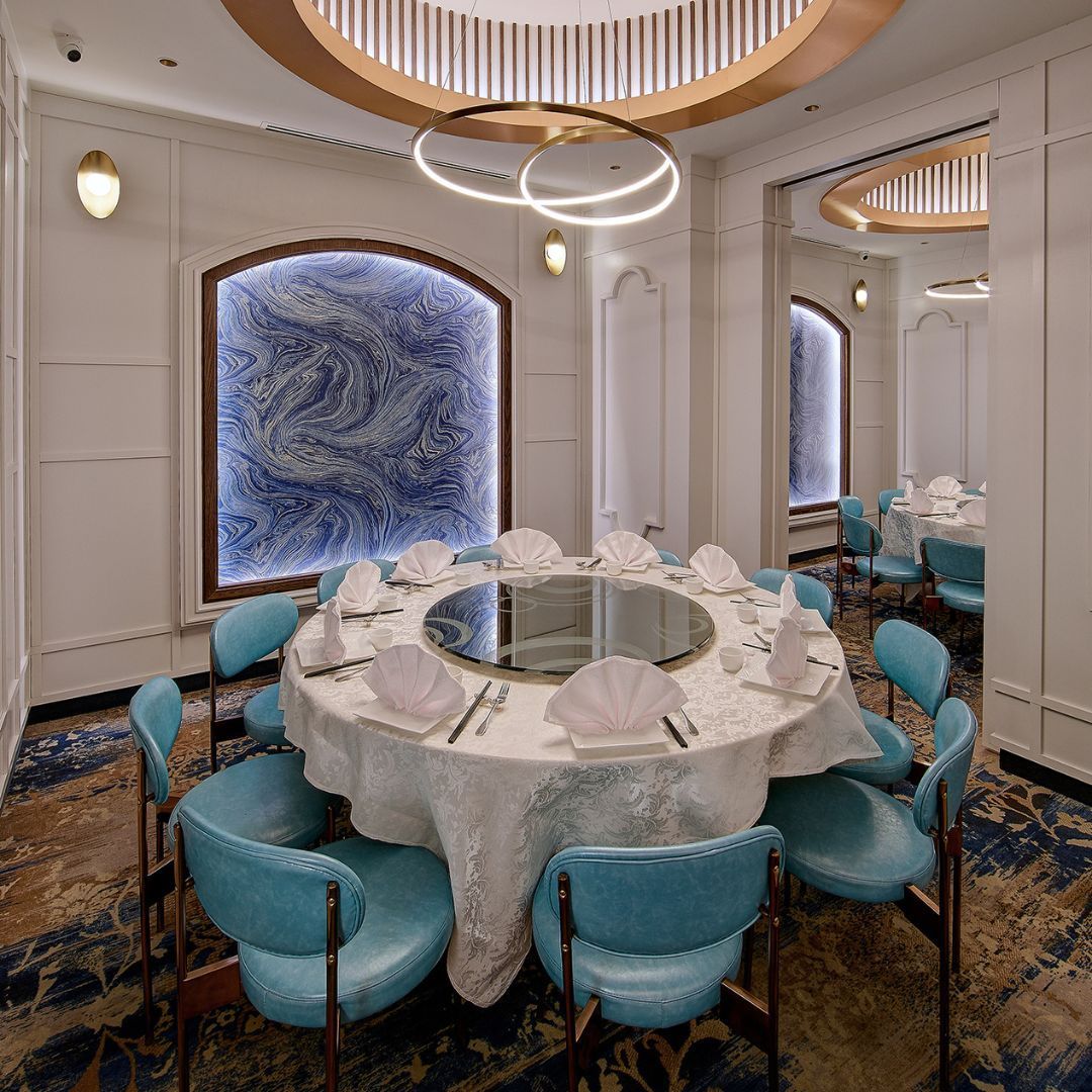 A dining room with a round table and blue chairs