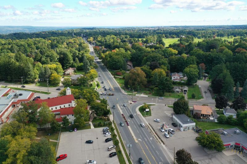 An aerial view of a busy intersection in a small town surrounded by trees.