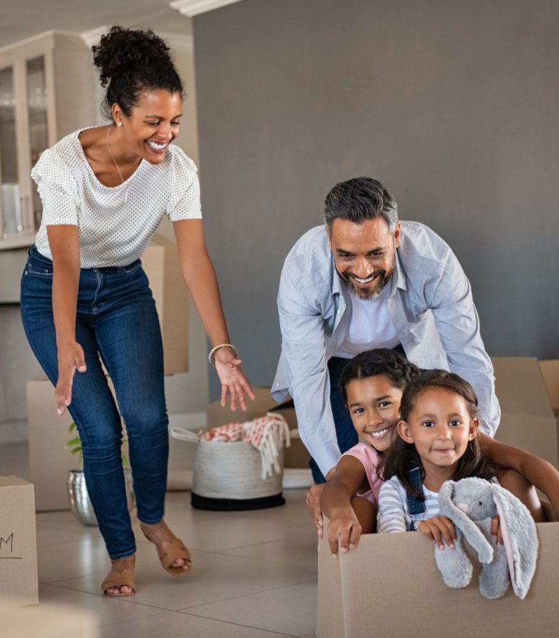 A family is playing in a cardboard box in their new home.