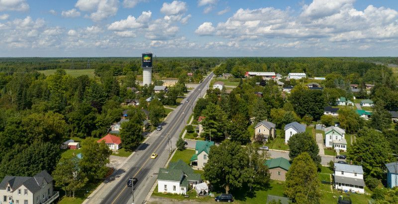 An aerial view of a small town with a water tower and a highway.