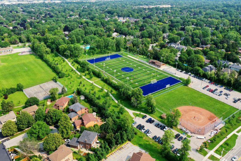 An aerial view of a football field and baseball field in a residential area.