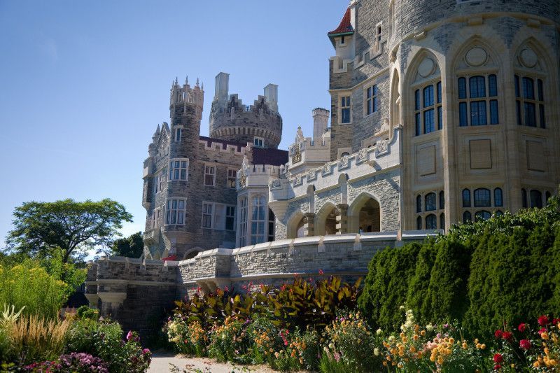 A large castle with a lot of windows and flowers in front of it.