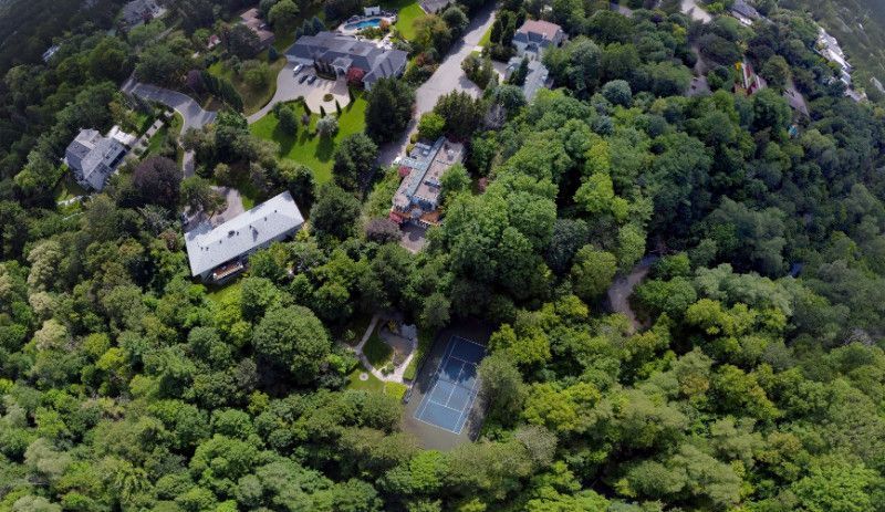 An aerial view of a residential area surrounded by trees and houses.
