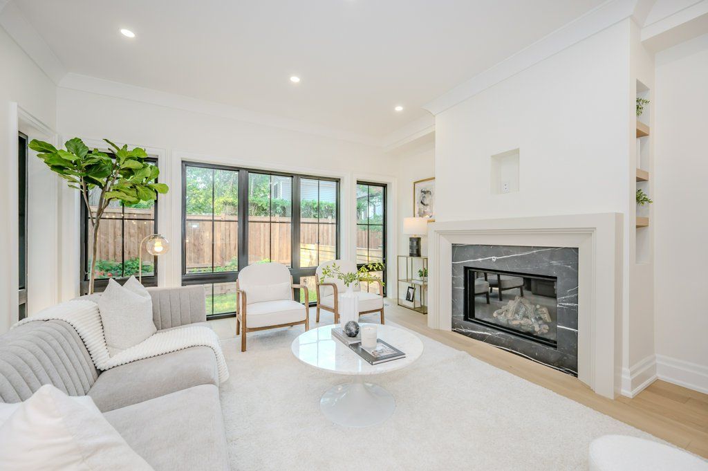 A living room with a couch , chairs , and a fireplace.