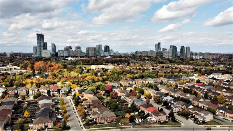 An aerial view of a residential area with a city skyline in the background.