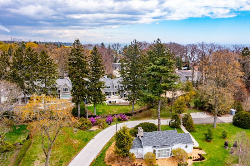 An aerial view of a house in a residential area surrounded by trees.