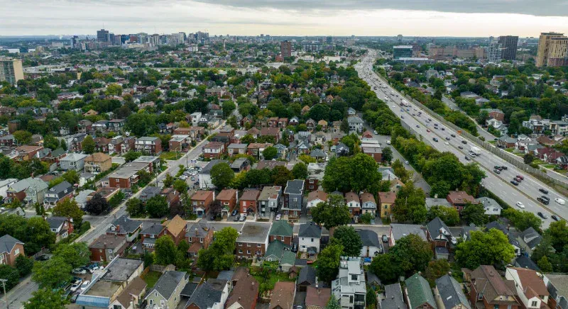 An aerial view of a residential area with a highway in the background.
